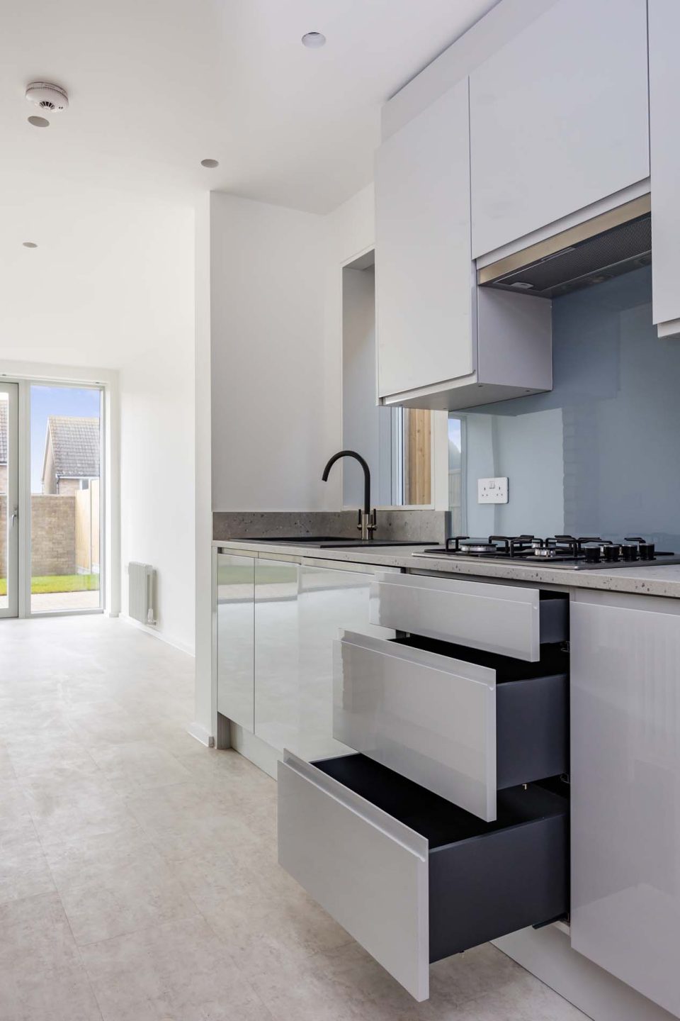 A kitchen with three open drawers