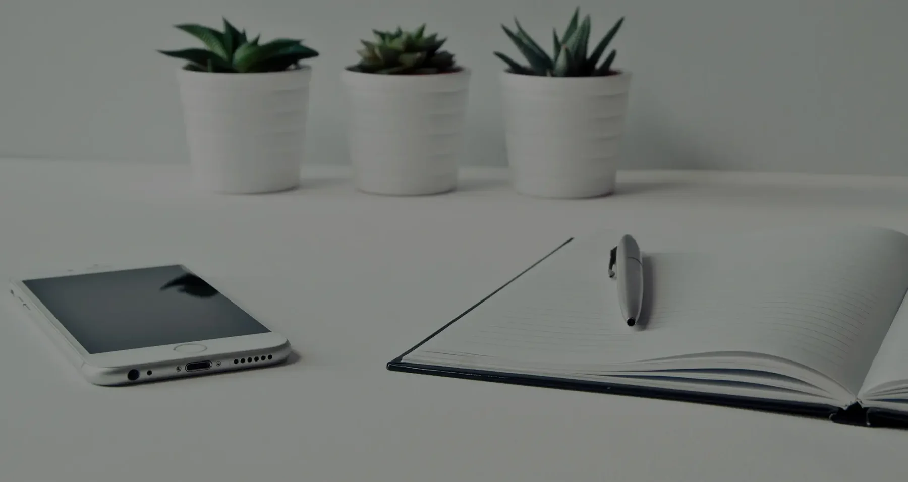 A desk with an open notebook and a pen